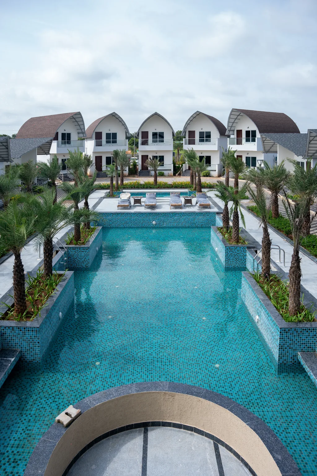 ALOHA Resorts — aerial view of resort pool and pool-facing rooms, day outing