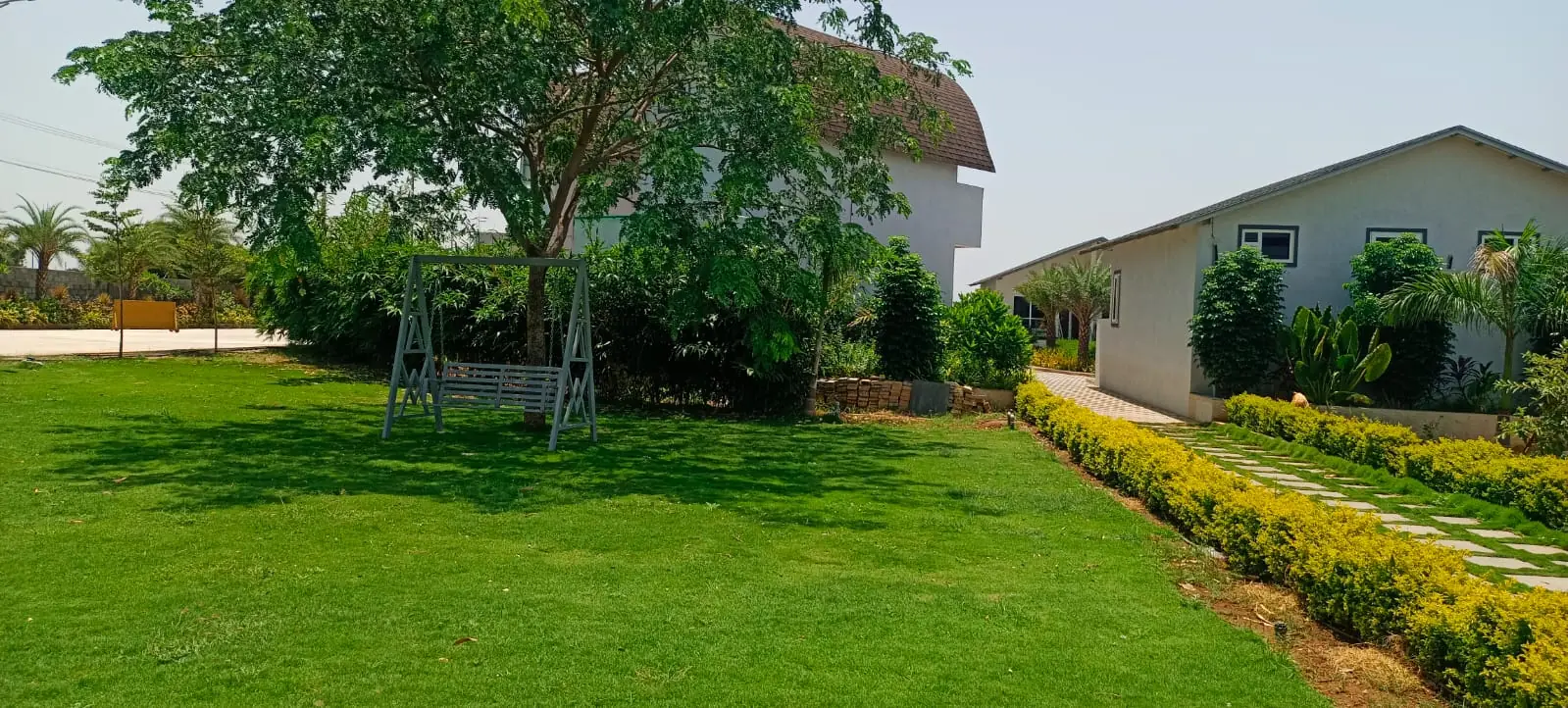 Landscaped villa lawn with swing at ALOHA Resorts — outdoor setting near Hyderabad airport